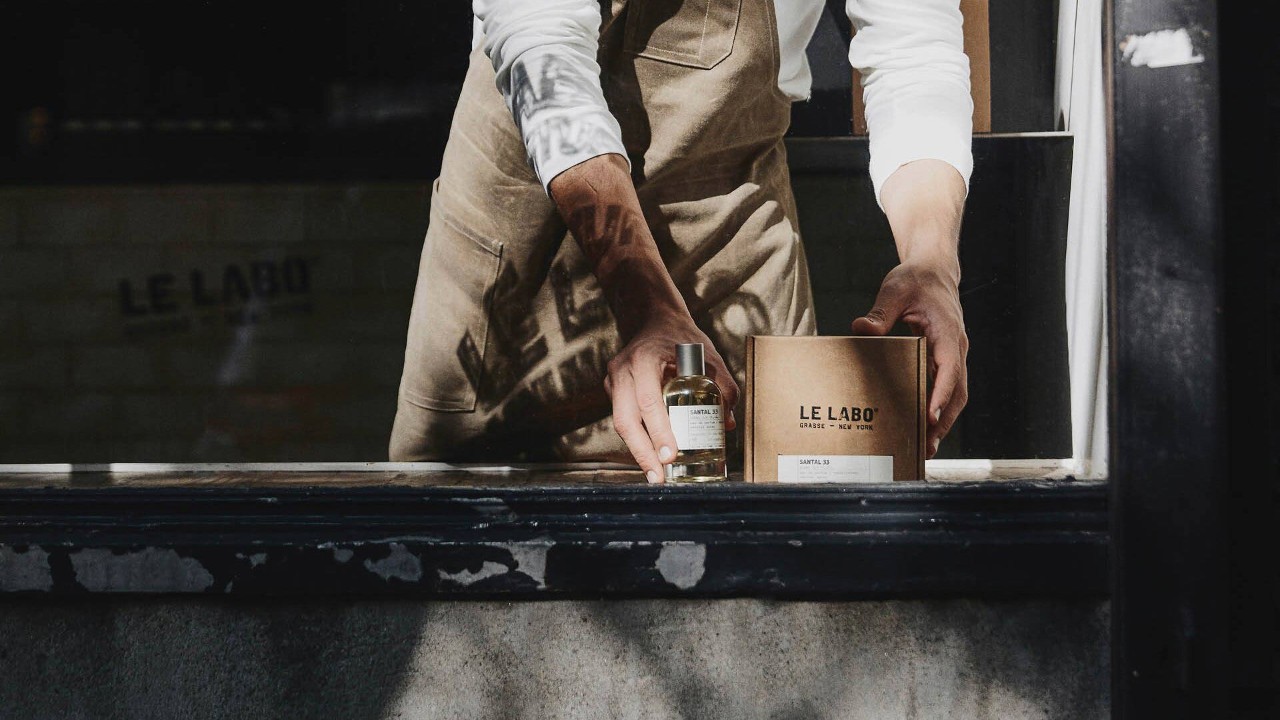 Man holding onto Santal 33, a perfume from a top perfume brand in Singapore